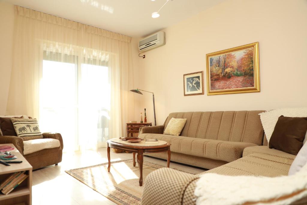 a living room with a couch and a table at Central Fortuzi Apartment in Tirana