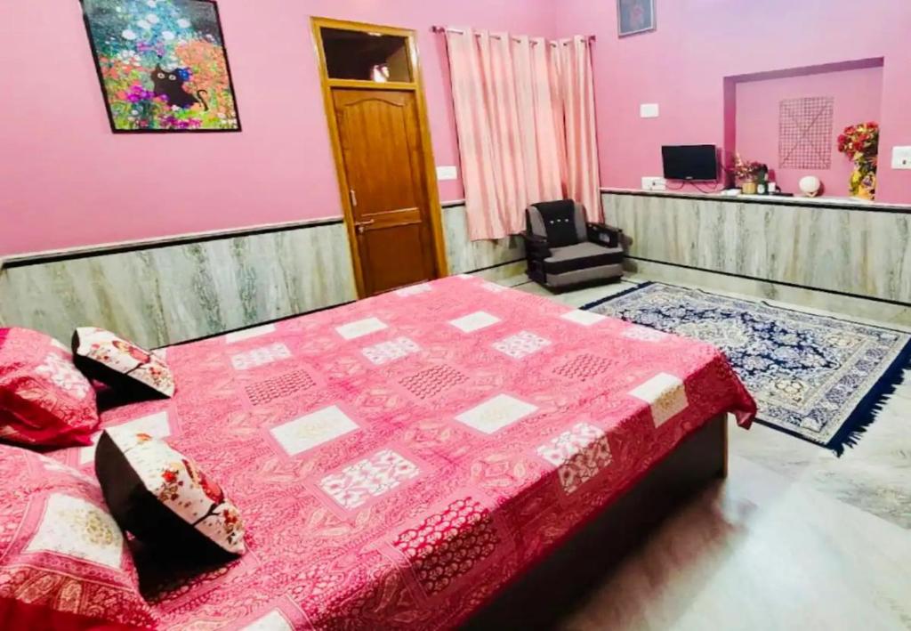 een roze slaapkamer met een bed en een stoel bij The Desert Palace in Bikaner