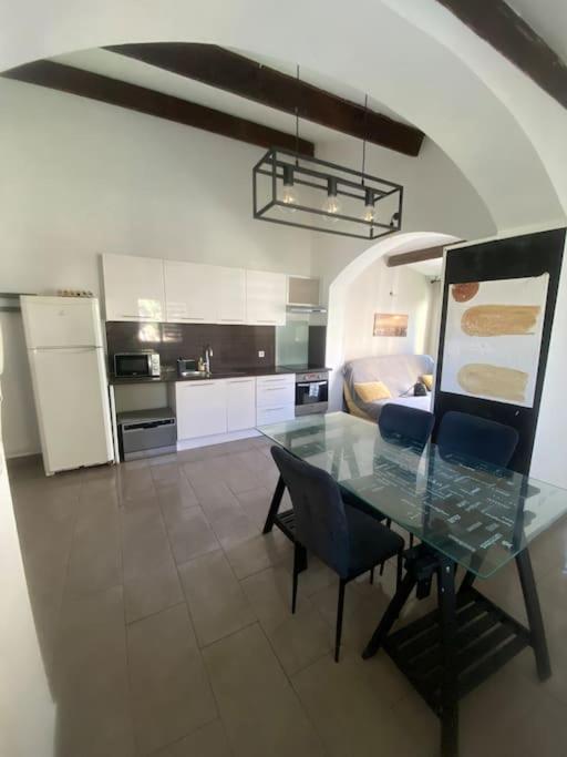 une cuisine avec une table en verre et des chaises bleues dans l'établissement Maison avec jardin, à Marseille