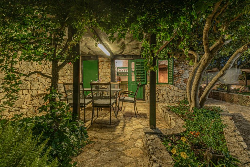 une terrasse avec une table, des chaises et des arbres dans l'établissement Villa Mariah with pool near National park Krka, à Bilice