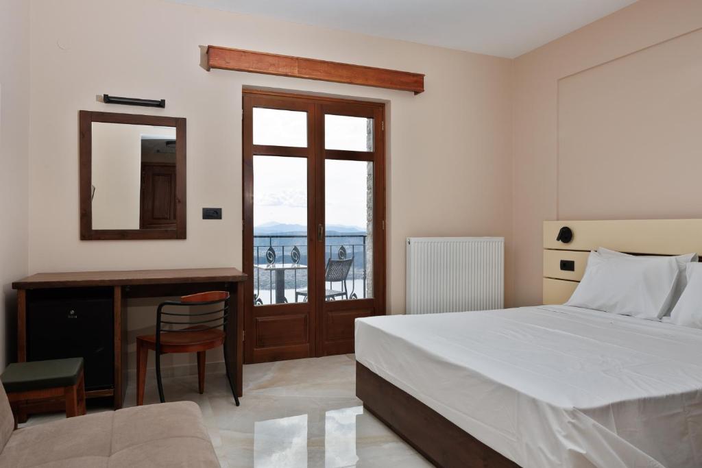 Schlafzimmer mit einem Bett, einem Schreibtisch und einem Spiegel in der Unterkunft The View Hotel in Ioannina