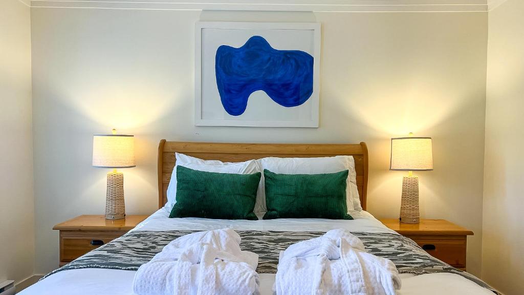 1 dormitorio con 1 cama con almohadas verdes en The Stonewater, en Madeira Park
