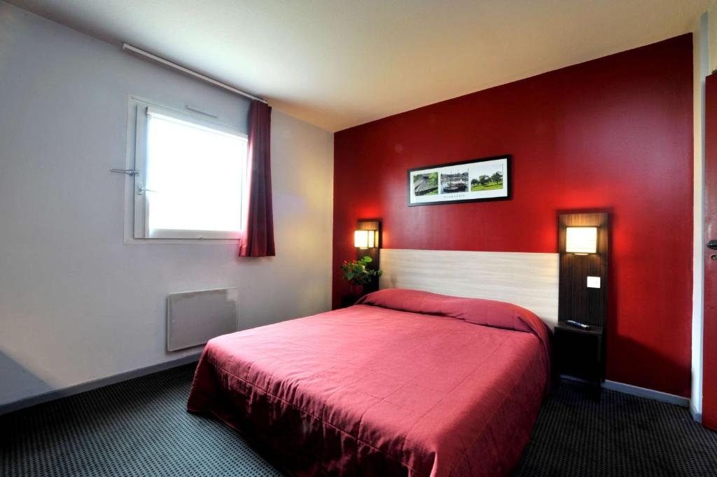 Brit Hotel St-Quentin/Nord في سانت كونتان: غرفة نوم حمراء مع سرير بجدار احمر