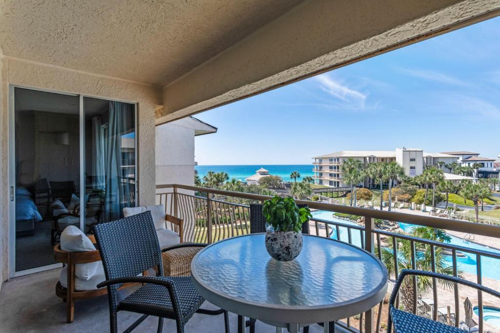 a table on a balcony with a view of the ocean at High Pointe Resort 414 in Rosemary Beach