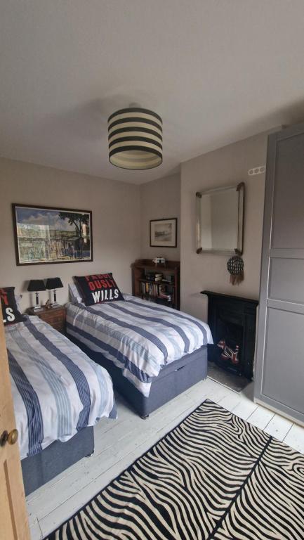 LincolnshireにあるStamford 2 bed character houseのベッドルーム1室(ベッド2台、暖炉付)