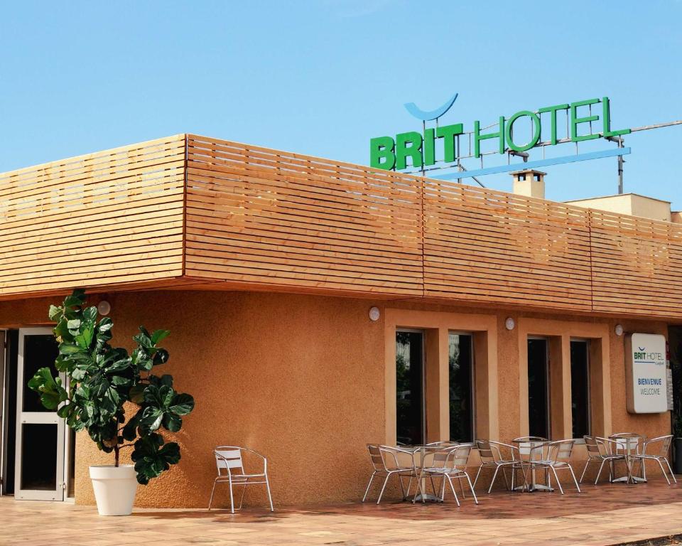 un edificio con sillas y un cartel encima en Brit Hotel Confort Castres en Castres