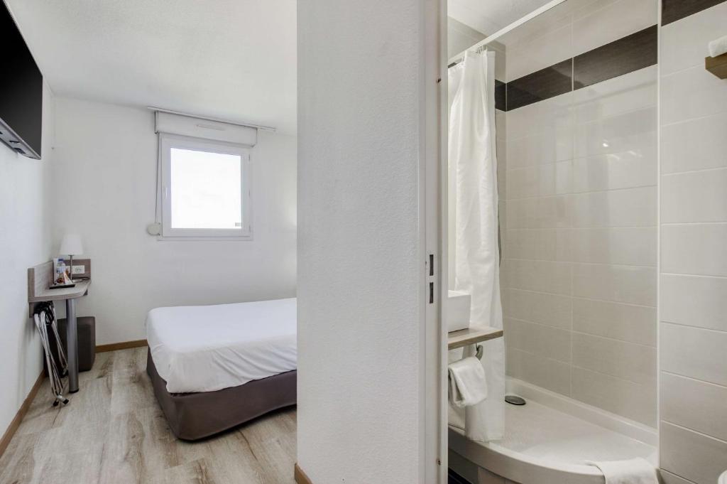 a white bedroom with a bed and a shower at Brit Hotel Clermont-lʼHérault in Clermont-lʼHérault