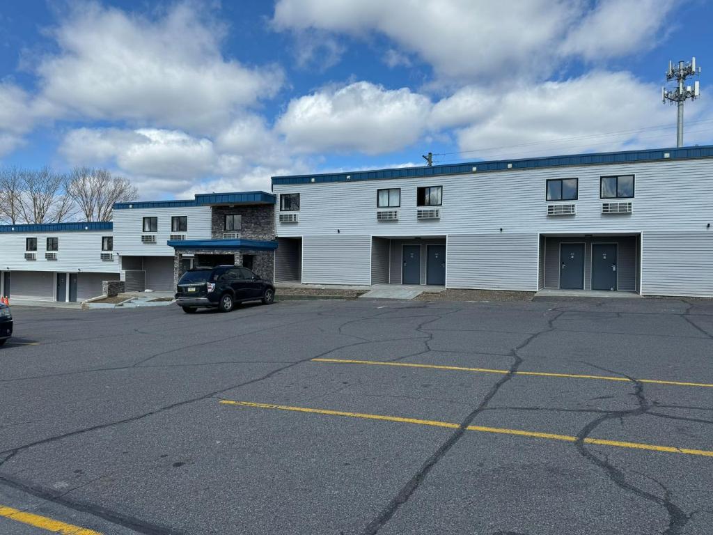 a parking lot in front of a white building at Rodeway Inn Moosic - Scranton in Moosic