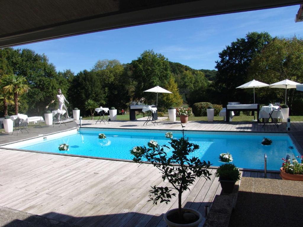a large swimming pool with a wooden deck at Brit Hotel du Golf Le Lodge in Salies-de-Béarn