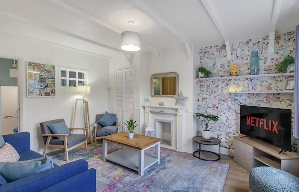 a living room with a blue couch and a fireplace at Cosy and Fresh Seaside Home - Parking in Sheringham