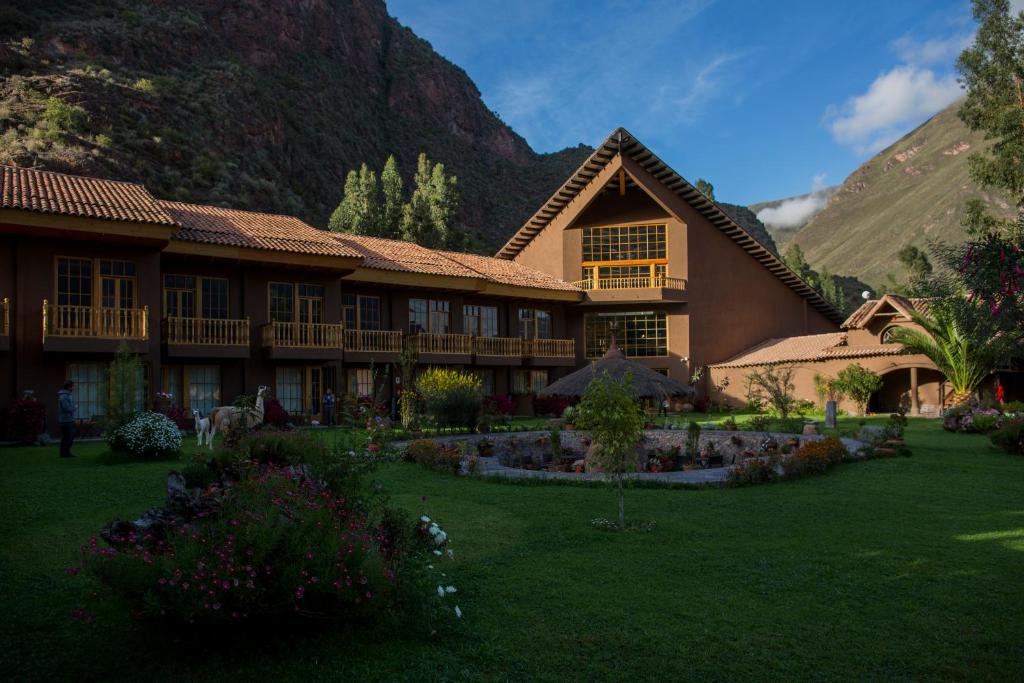 um grande edifício com um jardim em frente a uma montanha em Lamay Lodge by Mountain Lodges of Peru em Cusco