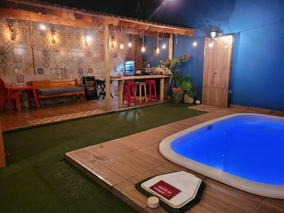 uma grande banheira azul num quarto com uma mesa em Casa com piscina aconchegante em Ribeirão Preto
