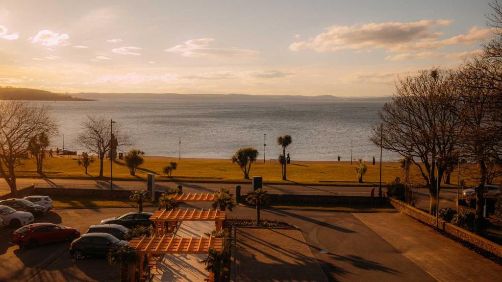 a group of cars parked next to a body of water at Brisbane House Hotel in Largs