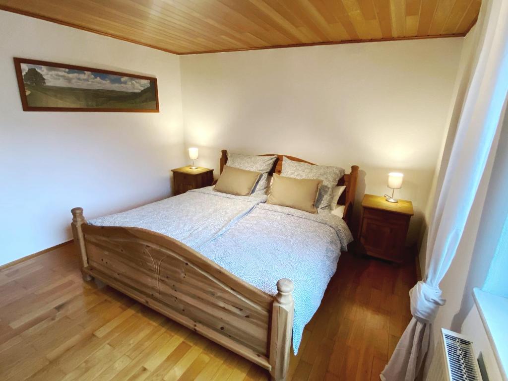 1 dormitorio con 1 cama con 2 mesitas de noche y 2 lámparas en Ferienwohnung am Walberla / Fränkische Schweiz, en Kirchehrenbach