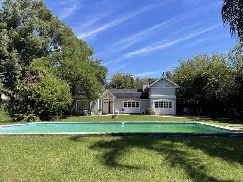 uma casa com piscina no quintal em Casa Leloir em Villa Leloir