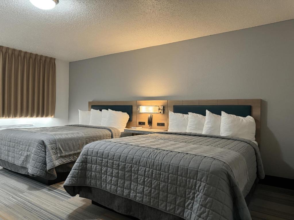 a hotel room with two beds and a window at Bearcat Inn and Suites in Maryville