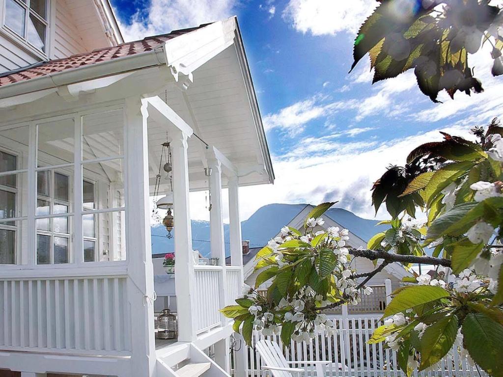 a white front porch of a house with mountains in the background at Villa Solvorn in Solvorn