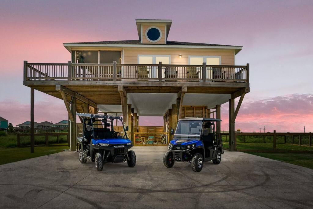 dois carrinhos de golfe estacionados em frente a uma casa em The Crystal Lobster em Bolivar Peninsula