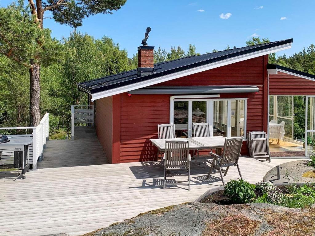 uma cabina vermelha com uma mesa e cadeiras num deque em Holiday home NYKÖPING II em Nyköping