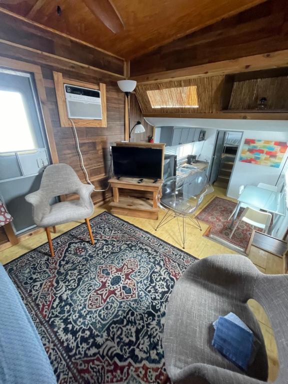 a living room with a tv and a couch and a rug at Updated houseboat on the river! in Fort Lauderdale