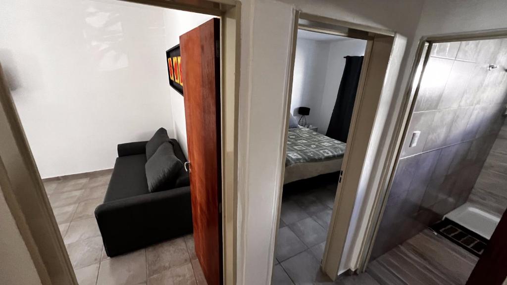 Habitación con espejo, sofá y dormitorio en Apartamentos Mamma Mia, en Córdoba