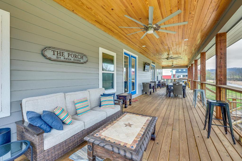 - une terrasse couverte avec un canapé et un ventilateur de plafond dans l'établissement Riverfront Arkansas Abode with Deck and Grill!, à Glenwood