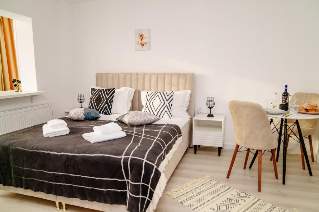 um quarto com uma cama, uma mesa e uma sala de jantar em Studio Lounge em Craiova