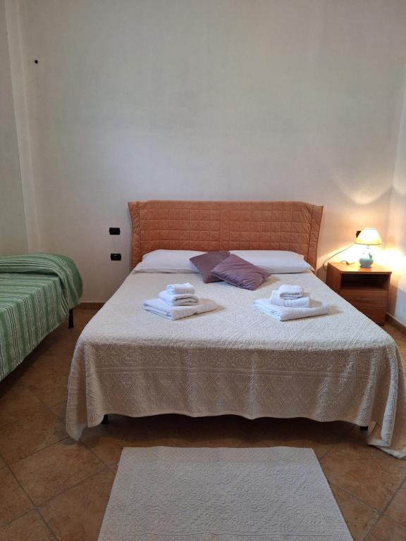 1 dormitorio con 1 cama con toallas en Casa vacanze Irgoli, en Irgoli