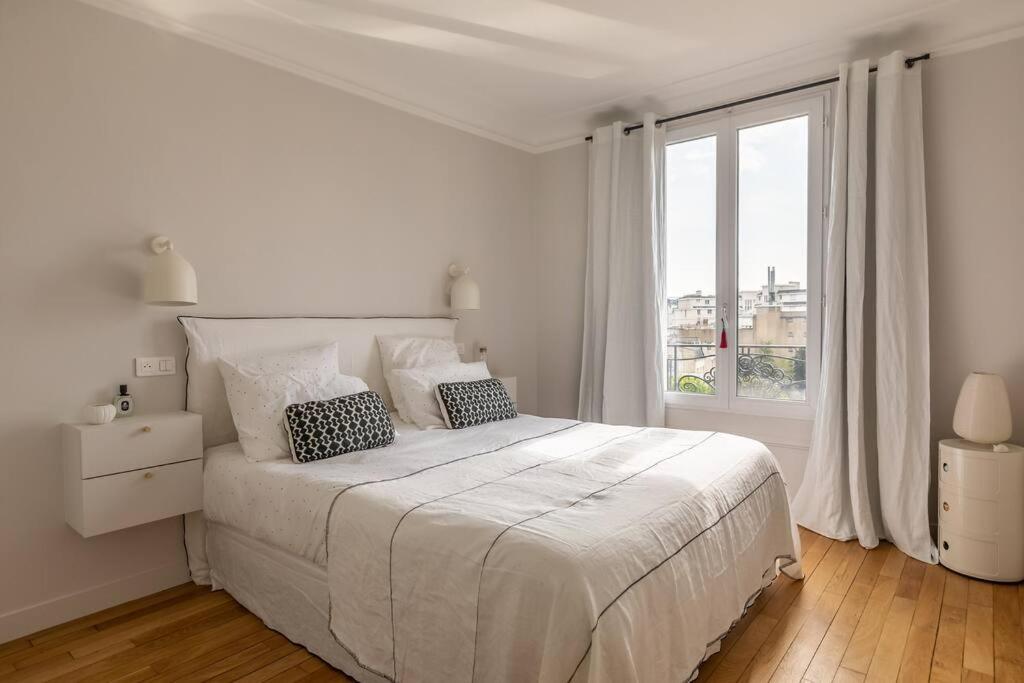 une chambre blanche avec un grand lit et une fenêtre dans l'établissement Le PAVILLON SUPERBE APPARTEMENT PROCHE ROLLAND GARROS &PRINCES, à Boulogne-Billancourt