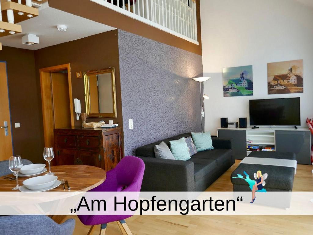 ein Wohnzimmer mit einem Sofa und einem Tisch in der Unterkunft Ferienwohnung am Hopfengarten in Lindau