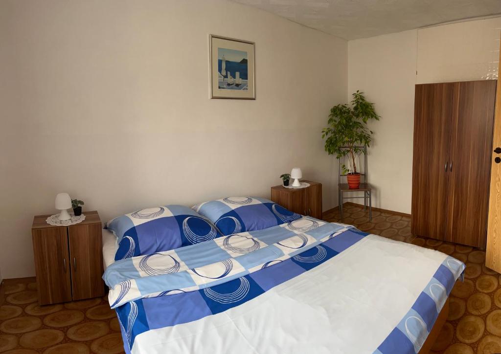 1 dormitorio con 1 cama grande con sábanas azules y blancas en Ubytování U Ropáků en Horní Slavkov