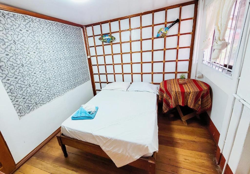 um pequeno quarto com uma pequena cama e uma janela em Hogar Marujita em Iquitos