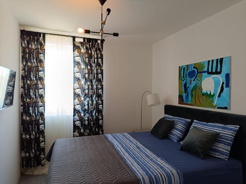 een slaapkamer met een blauw bed en een raam bij Villa Minerva Zadar in Murvica