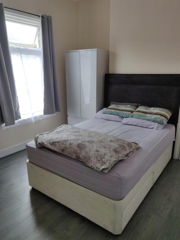 uma cama num quarto com uma janela em AR Homes em Middlesbrough