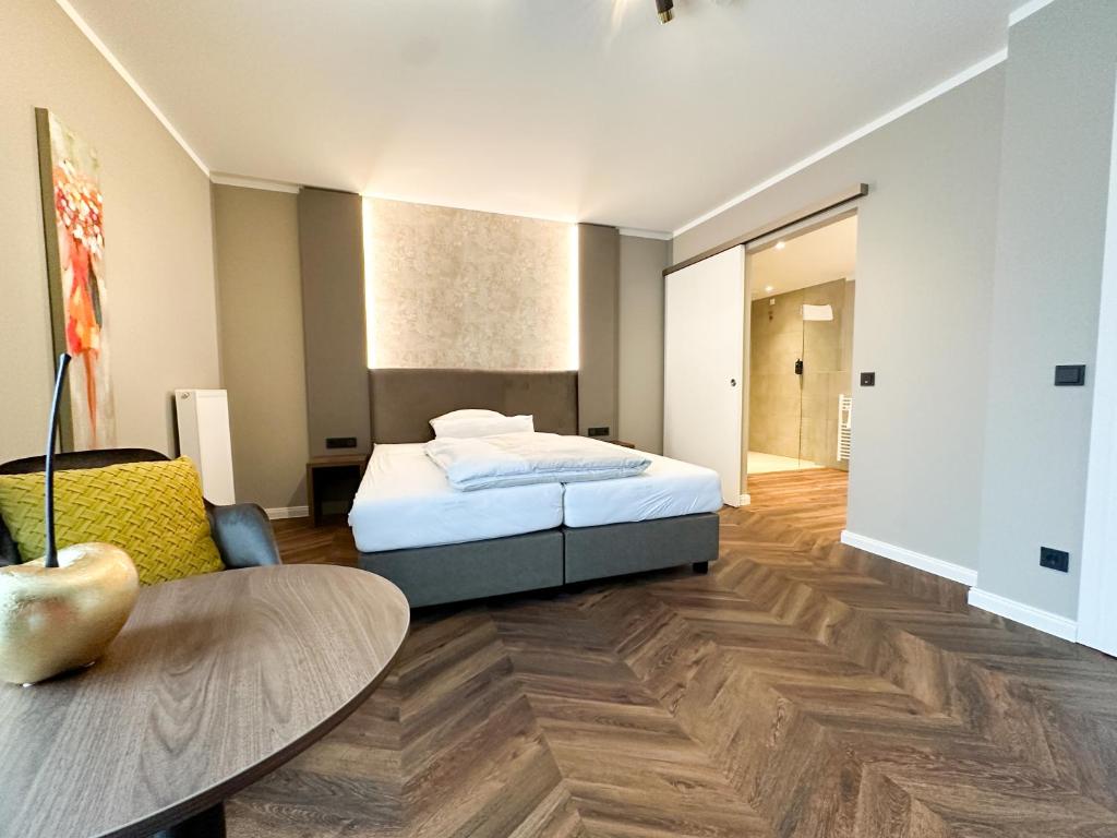 Un dormitorio con una cama y una mesa. en Hotel Restaurant Hackmann-Atter en Osnabrück
