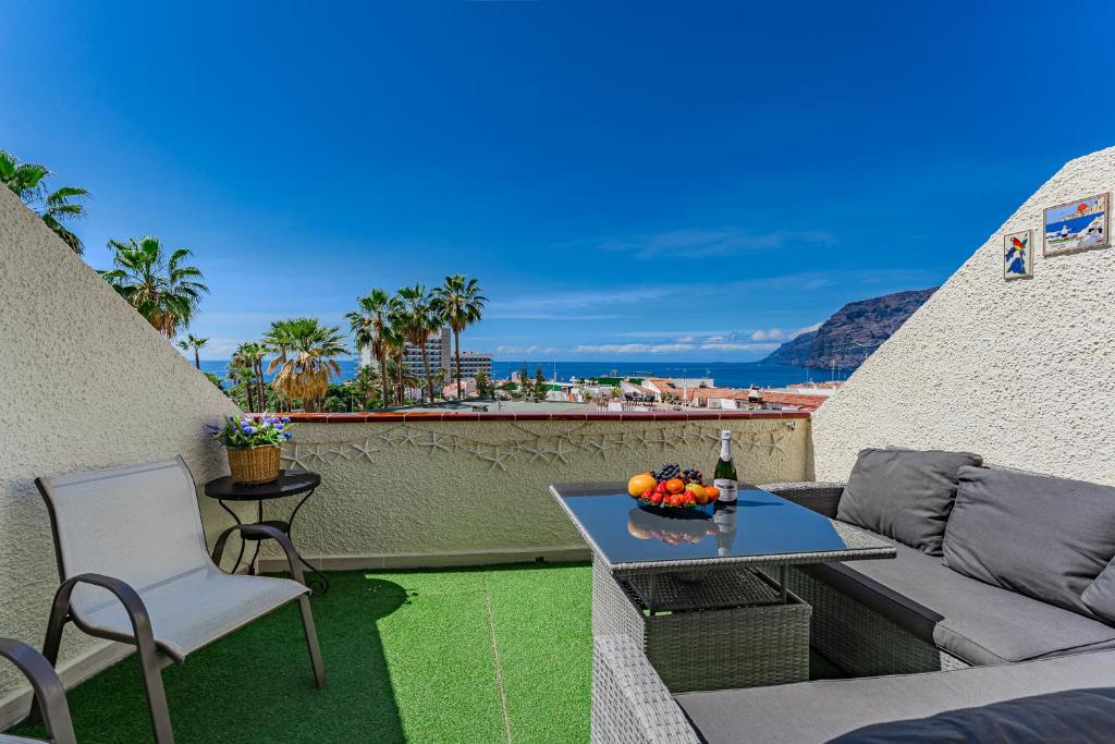 a patio with a couch and a table and chairs at 2bedroom LosGigantes Amazing View Free Parking Fibre in Acantilado de los Gigantes