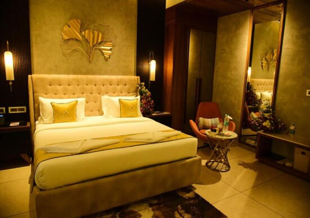 a bedroom with a large bed and a table at Hotel Seven Inn (R S Gorup Near Delhi Airport) in New Delhi