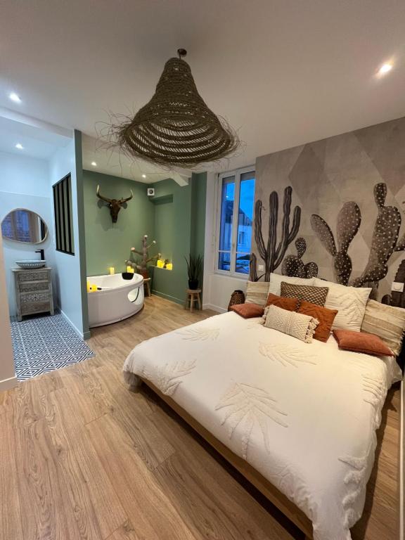 1 Schlafzimmer mit einem großen Bett und einem Badezimmer in der Unterkunft Suite avec Jacuzzi, 15 min de Disneyland Paris - Le Nid d'Eliyah in Nanteuil-lès-Meaux