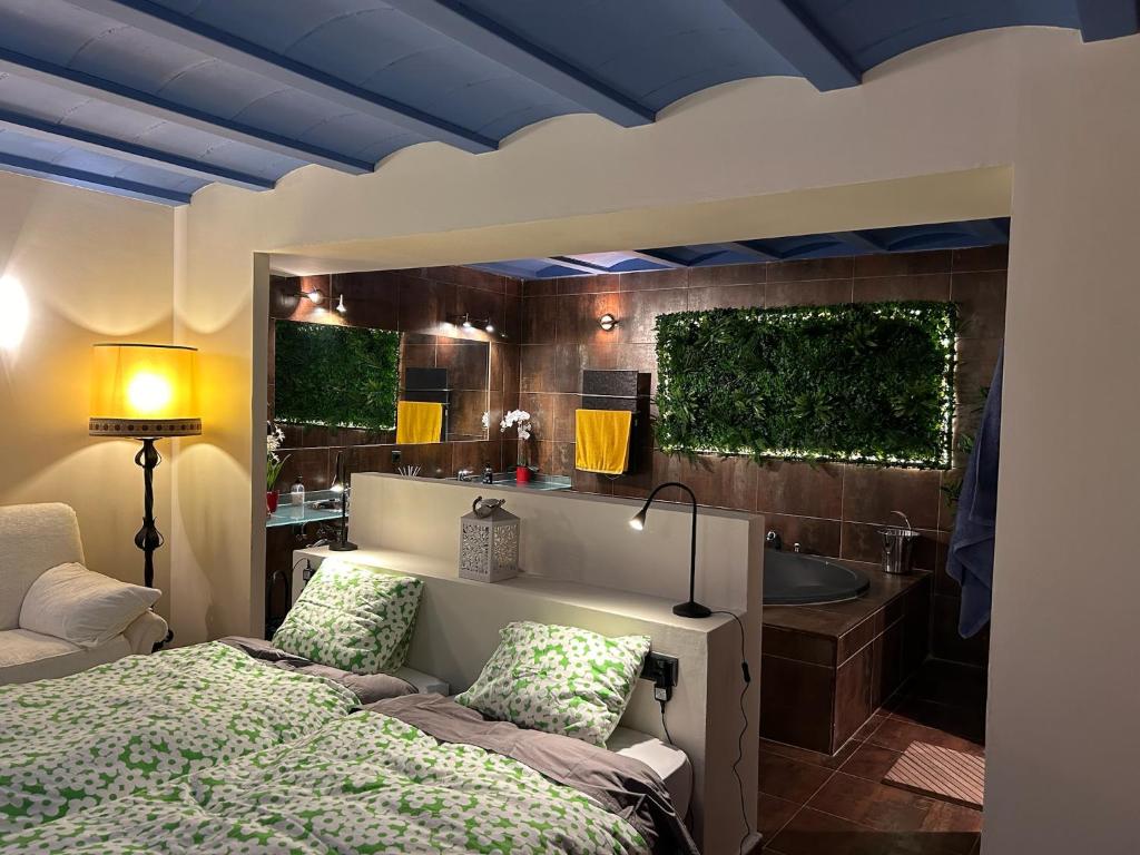- une chambre avec un lit et une salle de bains pourvue d'une baignoire dans l'établissement Apartamento ático-dúplex en Casa Rural Fundanal en Hoz de Jaca, à Hoz de Jaca