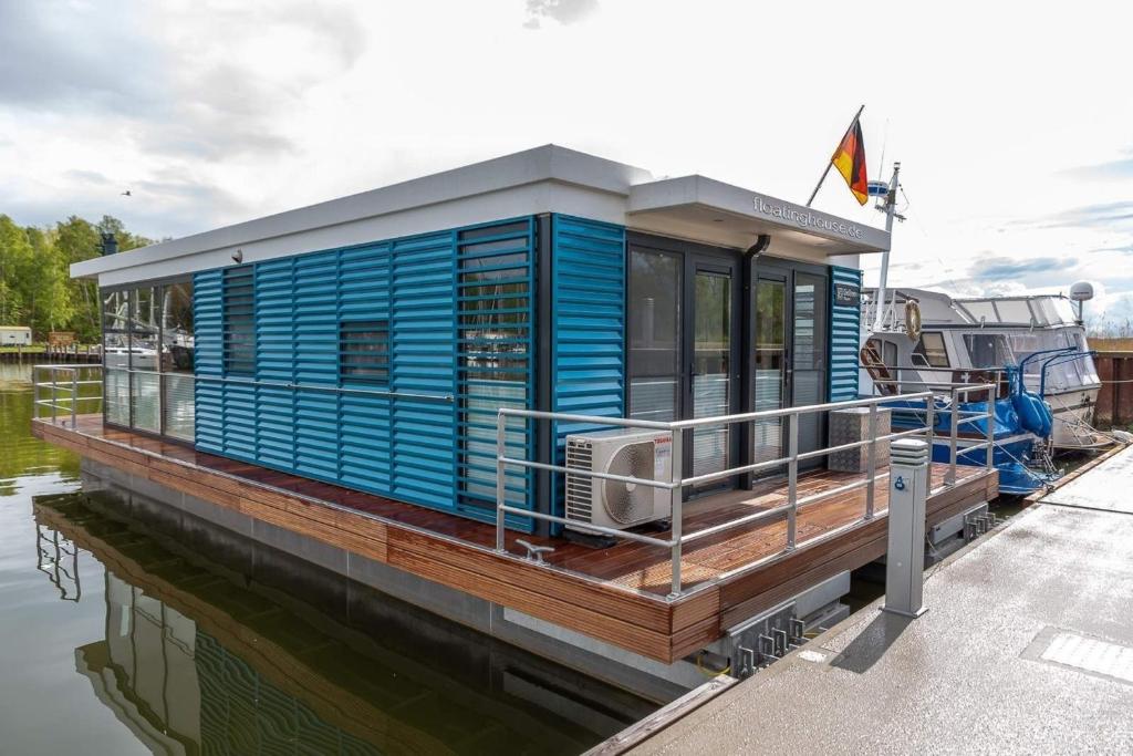 a blue house on a boat on the water at Hausboot LP7 in Peenemünde