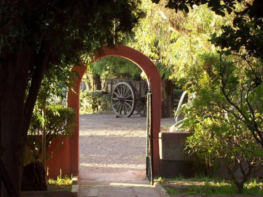 an archway leading into a garden with a cannon at Casa de Campo histórica el ñango in San Martín
