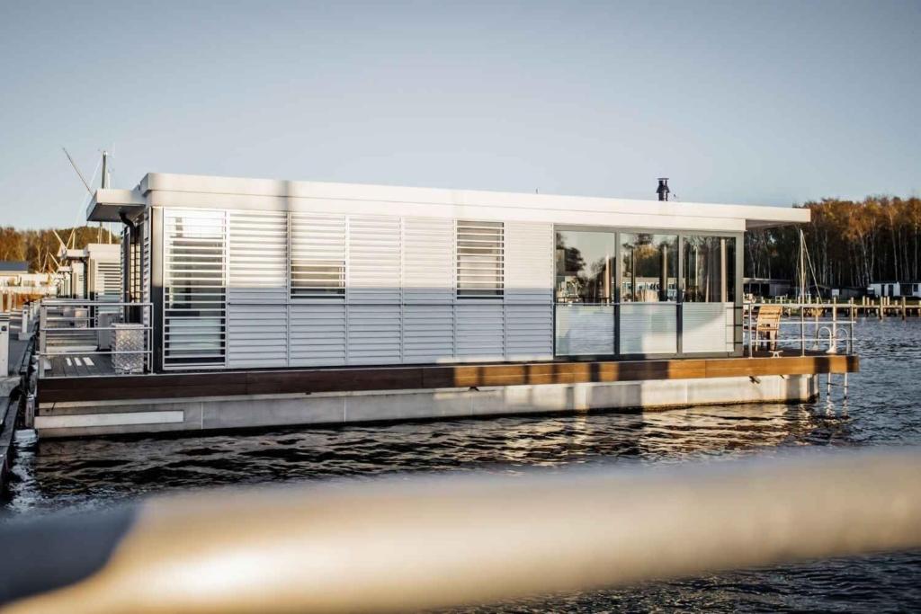 a building on a dock on a body of water at Hausboot Krosse Krabbe - LP6 in Peenemünde