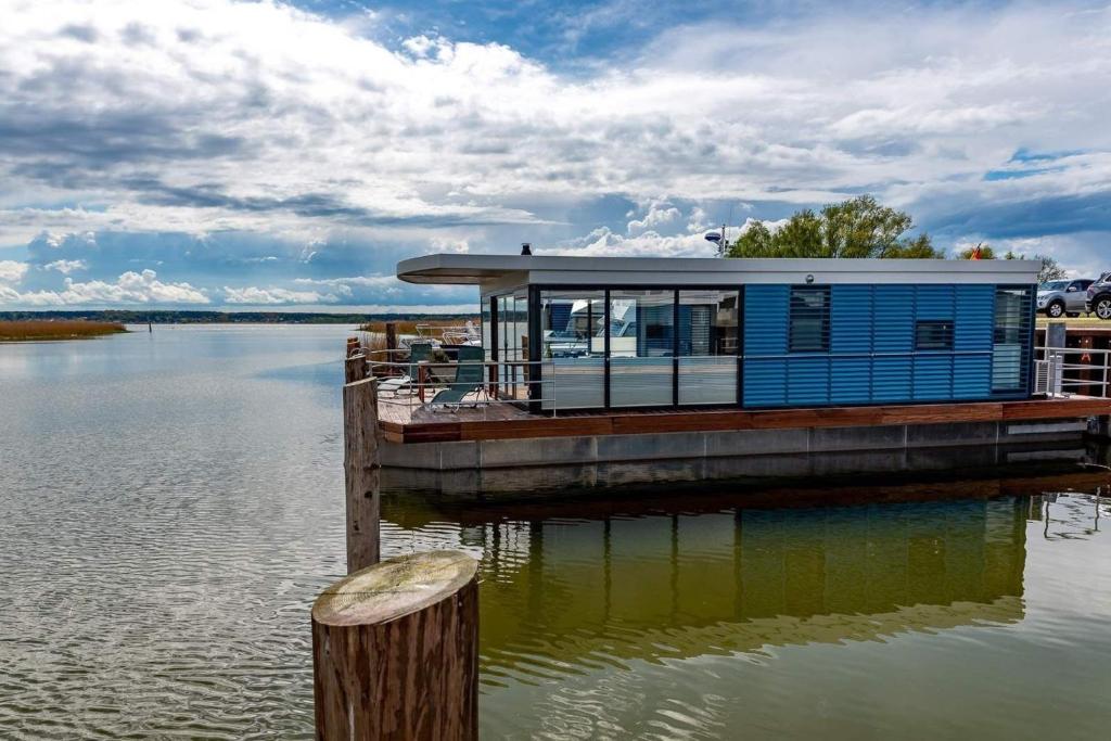 a house on a dock on a body of water at Hausboot LP1 in Peenemünde