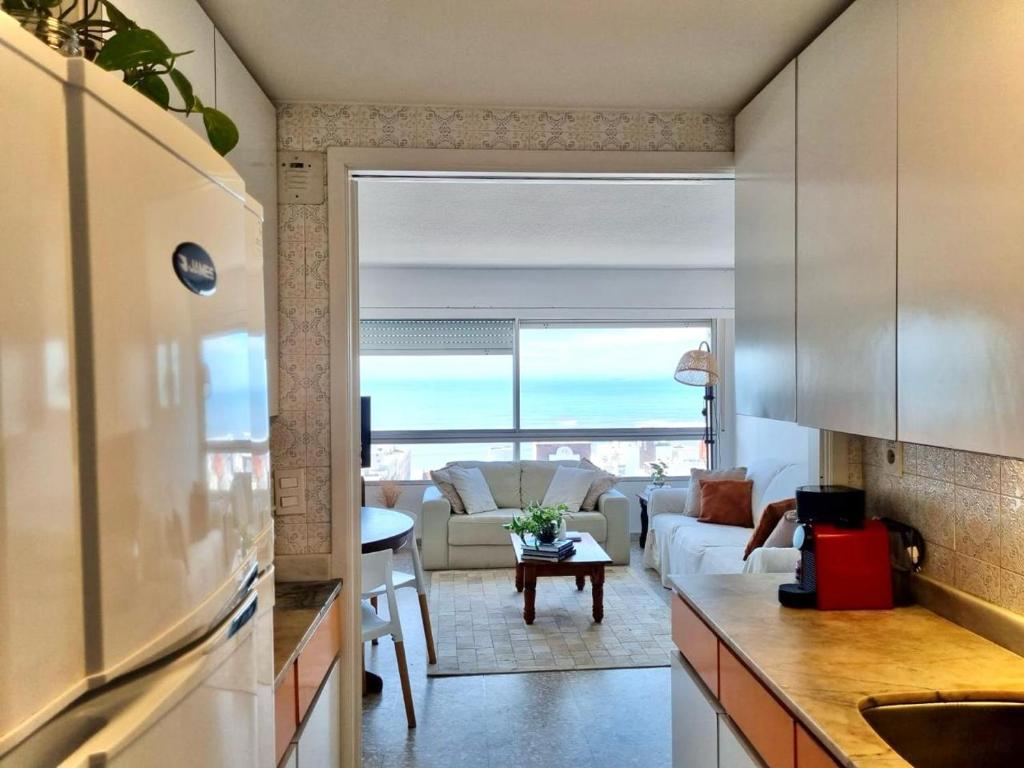 a kitchen and living room with a view of the ocean at TORRE806 VISTA MAR na PENÍNSULA en PUNTA DEL ESTE in Punta del Este