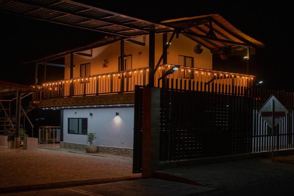 um edifício com uma varanda com um portão à noite em Finca-Hotel en Guatape em El Peñol
