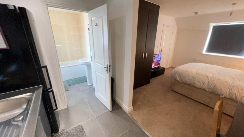 1 dormitorio con 1 cama y baño con bañera en Apartment suites in Broughton, Milton keynes en Broughton