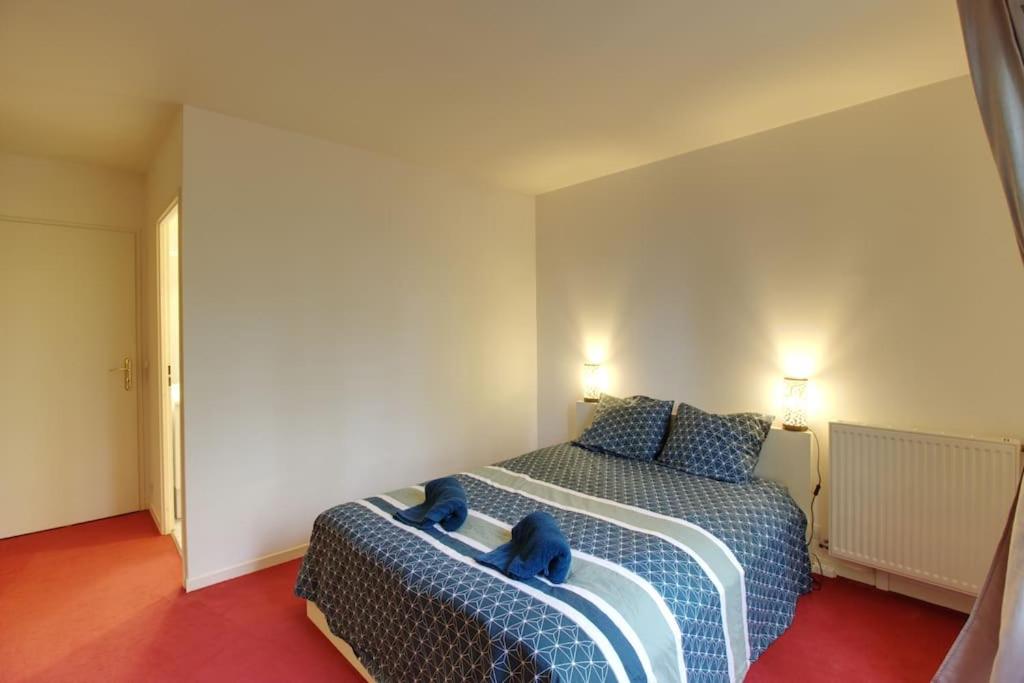 1 dormitorio con 1 cama con almohadas azules en Bel appartement situé face à la Vallée Shopping à quelques minutes de Disney, en Serris