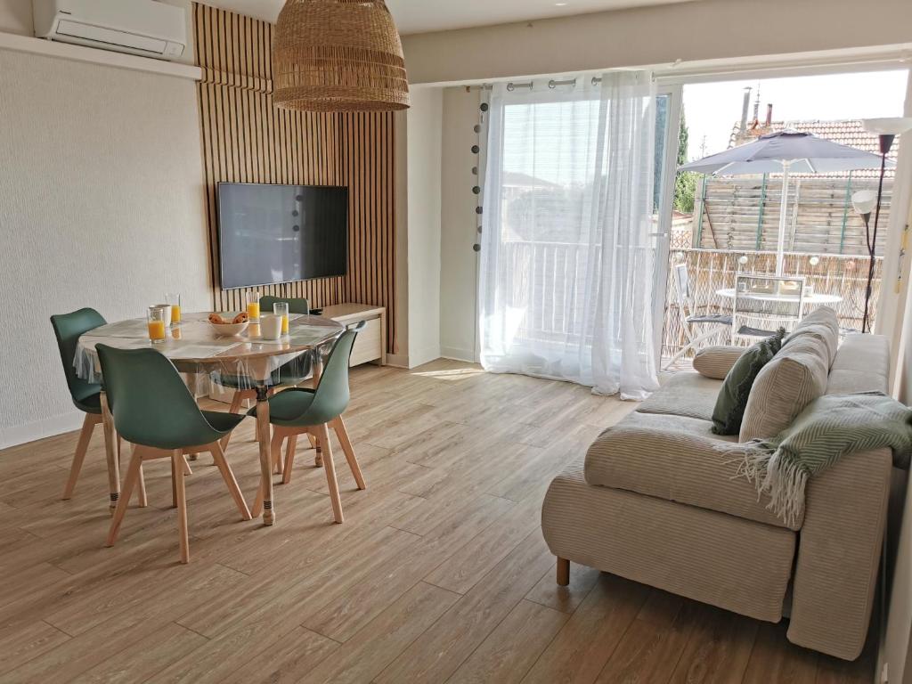 un salon avec une table et un canapé dans l'établissement Appart'Cosy - clim - terrasse - ascenseur, à Cavaillon