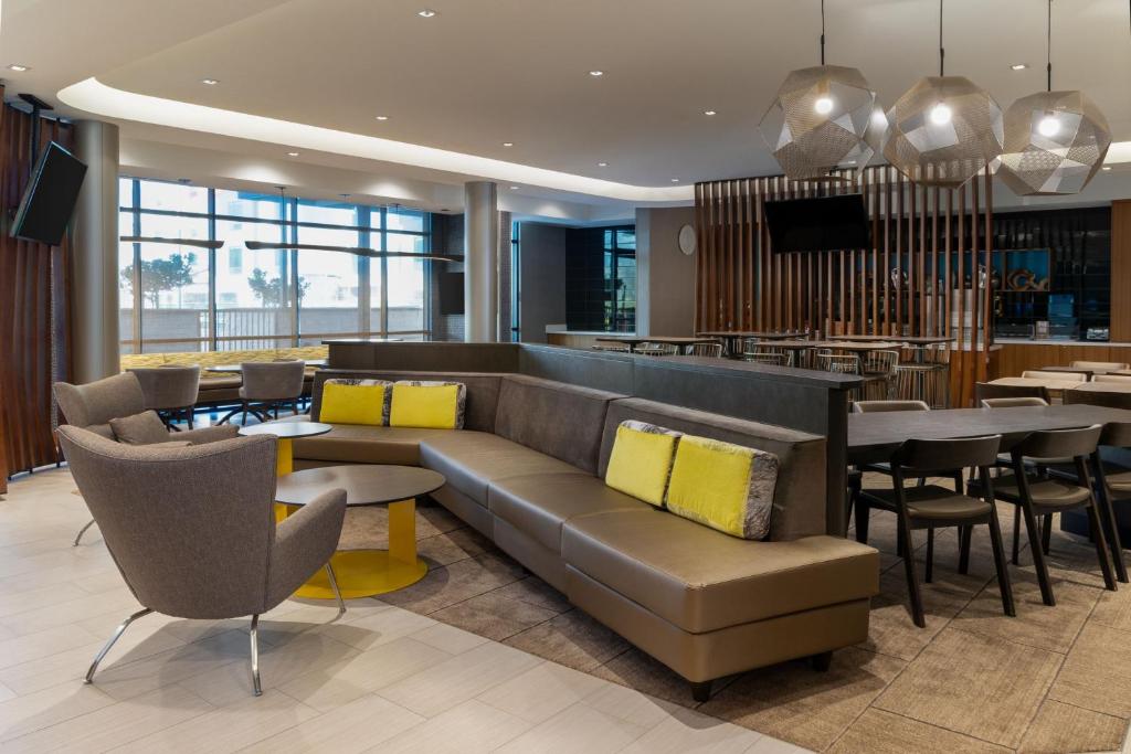 SpringHill Suites by Marriott Pleasanton في بليزانتون: لوبي فيه كنب وكراسي ومطعم
