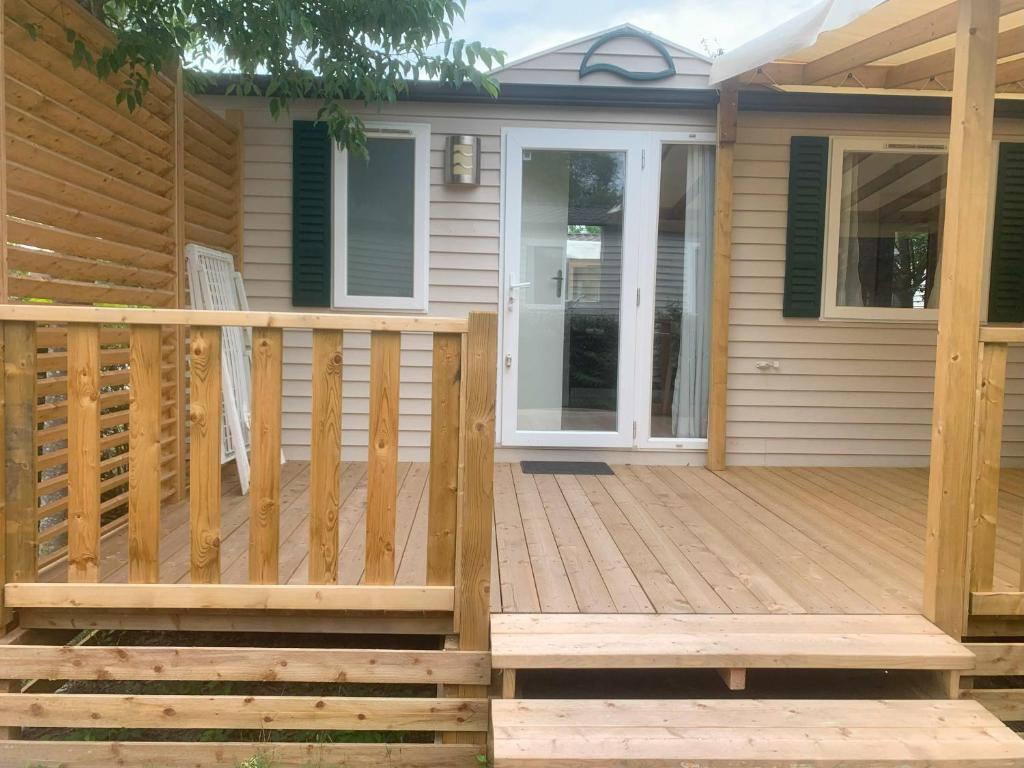 a house with a wooden deck with a door at Vacances en Provence en mobil home in La Roque-dʼAnthéron